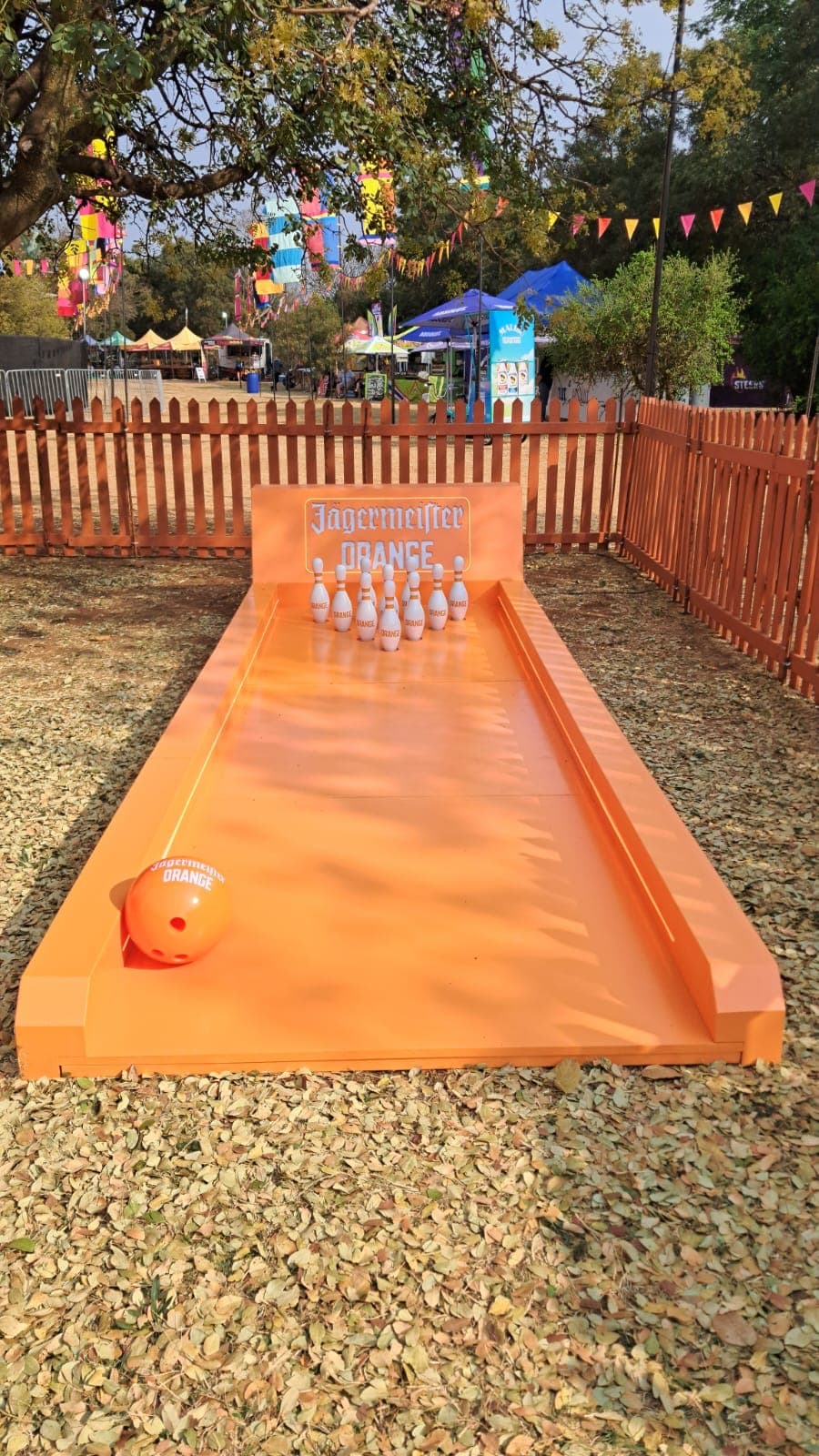 A custom Jagermeister Orange mini bowling lane set up outdoors at a festival